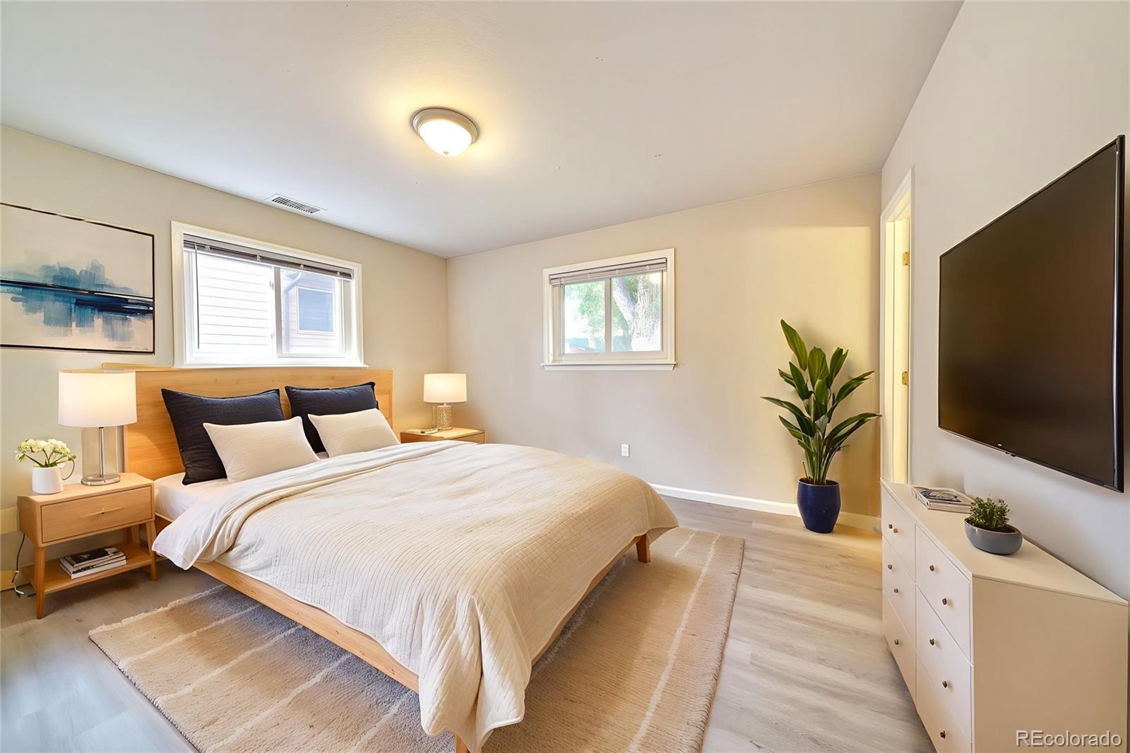 1206 Westmoreland Road Colorado Springs, CO 80907 - Photo 10 of 33 a bedroom with a large bed and a flat screen tv