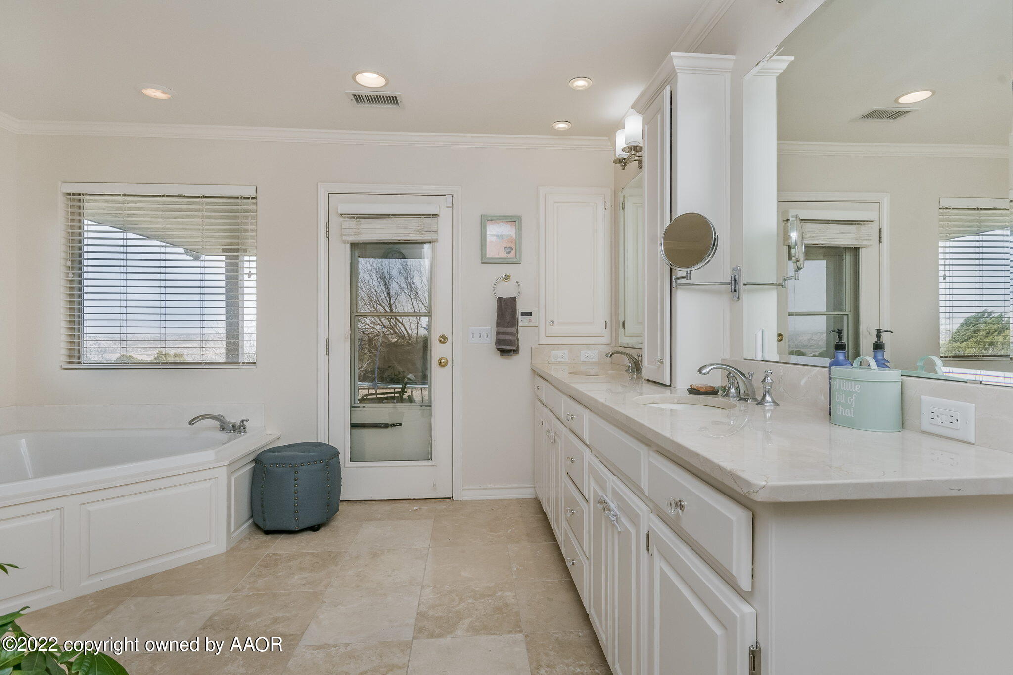 327 Lake Ridge Road Canyon, TX 79015 - Photo 16 of 31 a spacious bathroom with a granite countertop sink a mirror a bathtub and next to a window