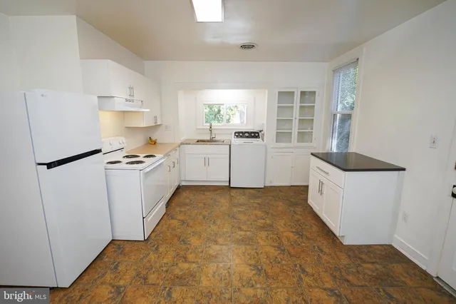 a kitchen with granite countertop cabinets a sink a window and stainless steel appliances