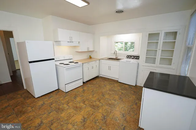 a view of a kitchen with refrigerator stove and wooden floor