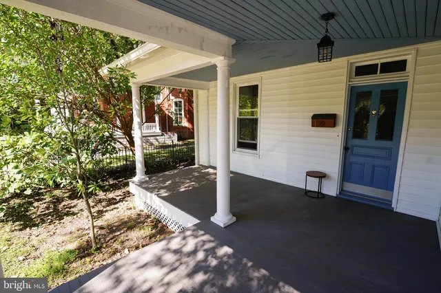 a view of a porch with a table and chairs and potted plants