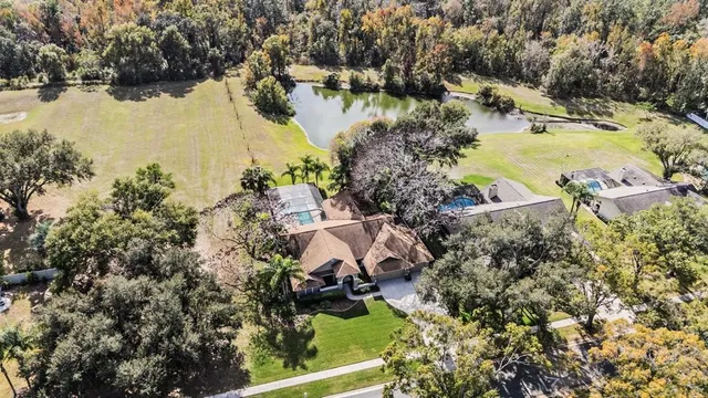 an aerial view of residential houses with outdoor space and lake view