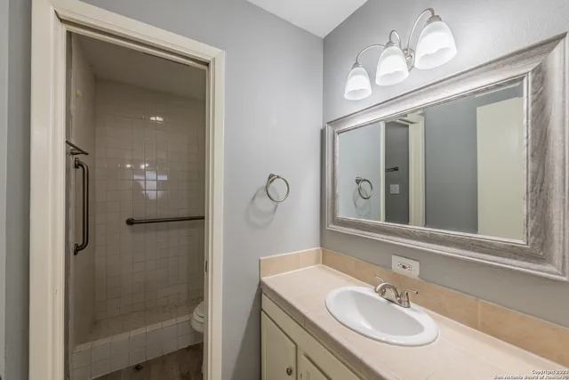 a bathroom with a sink a light fixture and a mirror