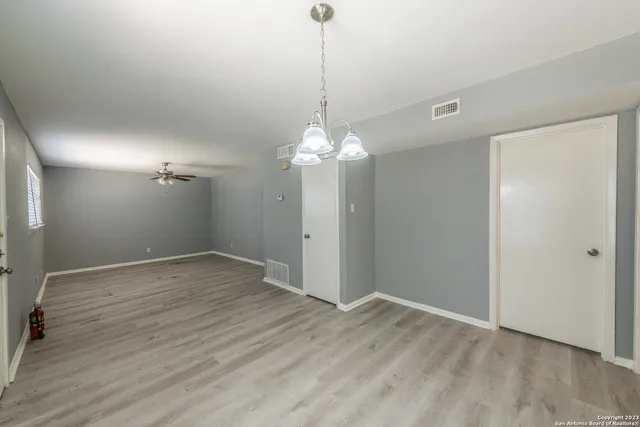 a view of a room with wooden floor and chandelier