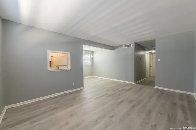 a view of an empty room with closet and a window