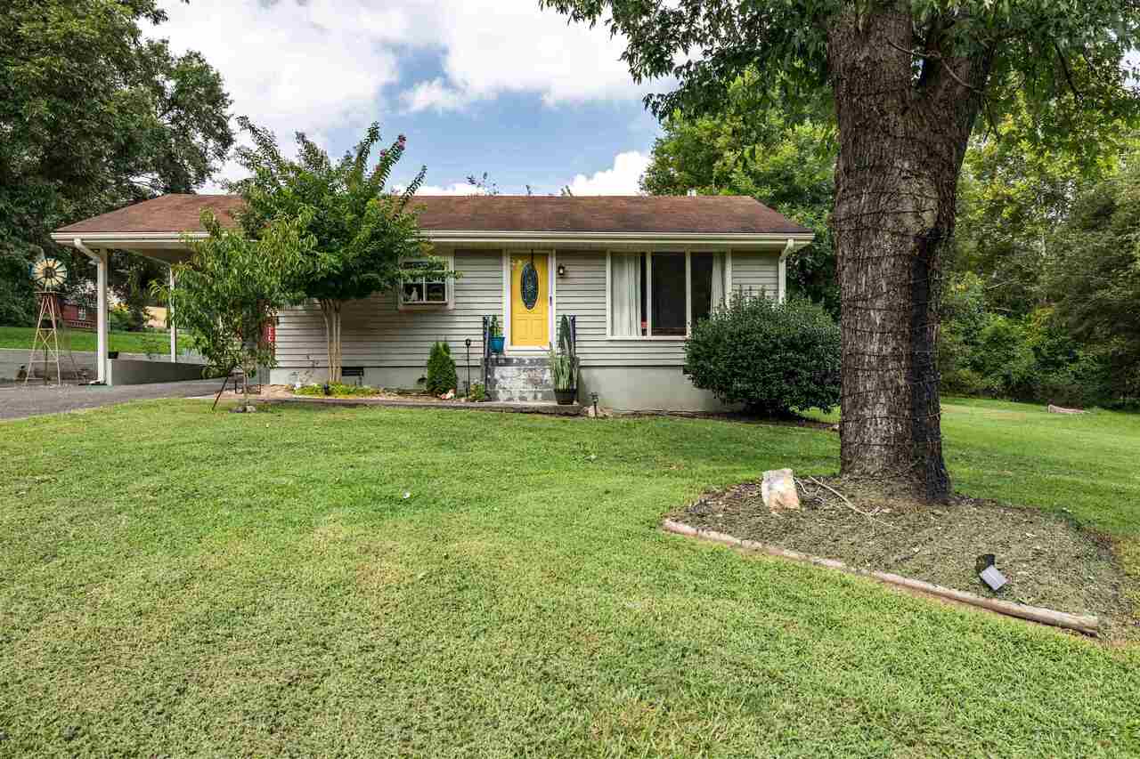 a front view of a house with garden and trees
