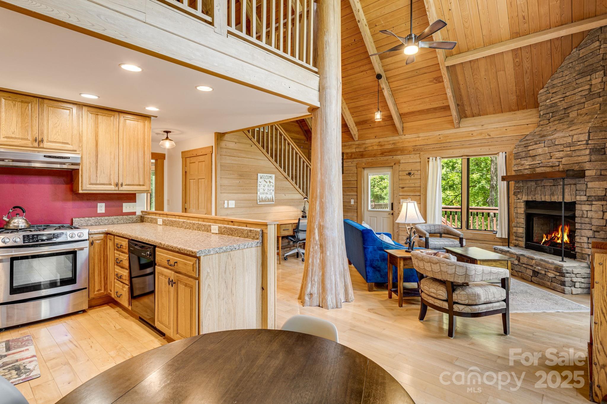 6018 Meadow Fork Road Hot Springs, NC 28743 - Photo 13 of 31 a open kitchen with stainless steel appliances granite countertop a stove top oven a sink dishwasher a dining table and chairs with wooden floor