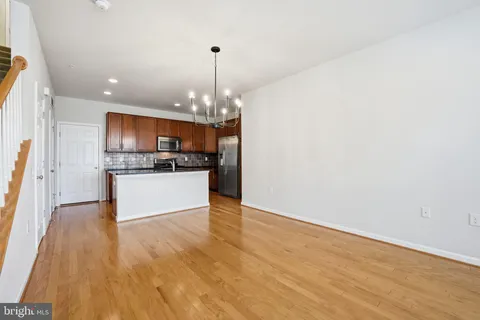 a view of a kitchen with a sink and dishwasher a refrigerator with wooden floor