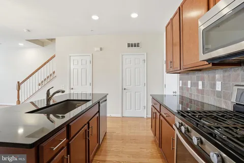 a kitchen with granite countertop a sink stove and cabinets