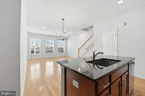 a kitchen with granite countertop a sink a stove and cabinets