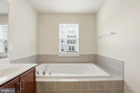 a bath tub sitting in a bathroom next to a window