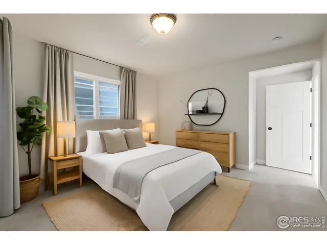 a bedroom with a bed mirror and a window