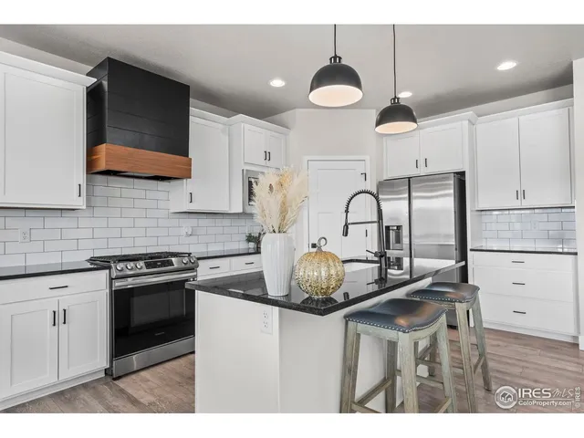 a kitchen with kitchen island granite countertop a sink a stove and cabinets