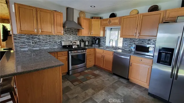 a kitchen with stainless steel appliances granite countertop a sink a stove and a refrigerator