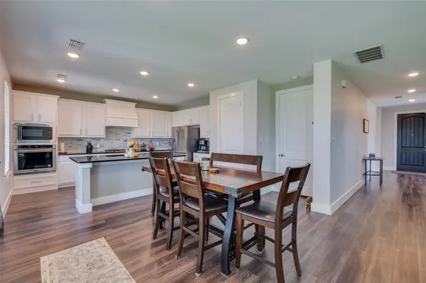 a view of kitchen with cabinets table and chairs
