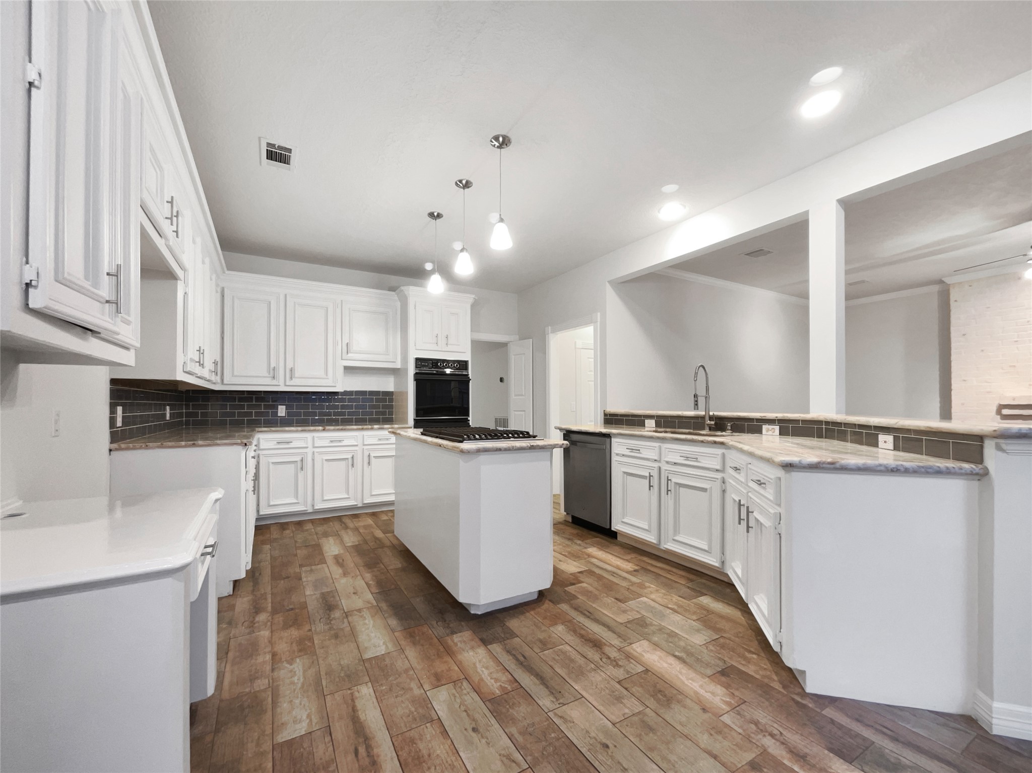 6107 Hampton Way Court Spring, TX 77389 - Photo 2 of 22 a large white kitchen with kitchen island a sink a stove a refrigerator and white cabinets
