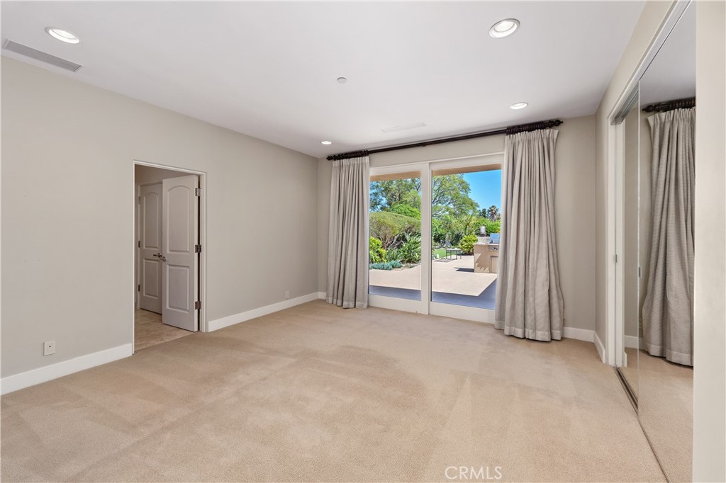 6533 Lago Lindo Rancho Santa Fe, CA 92067 - Photo 39 of 57 an empty room with large windows and garden view