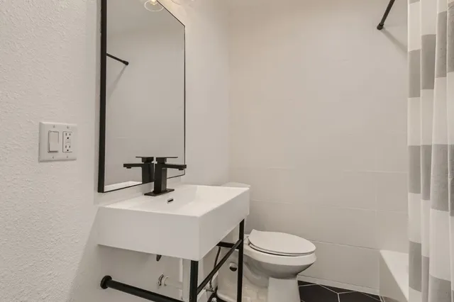 a bathroom with a sink a toilet and mirror