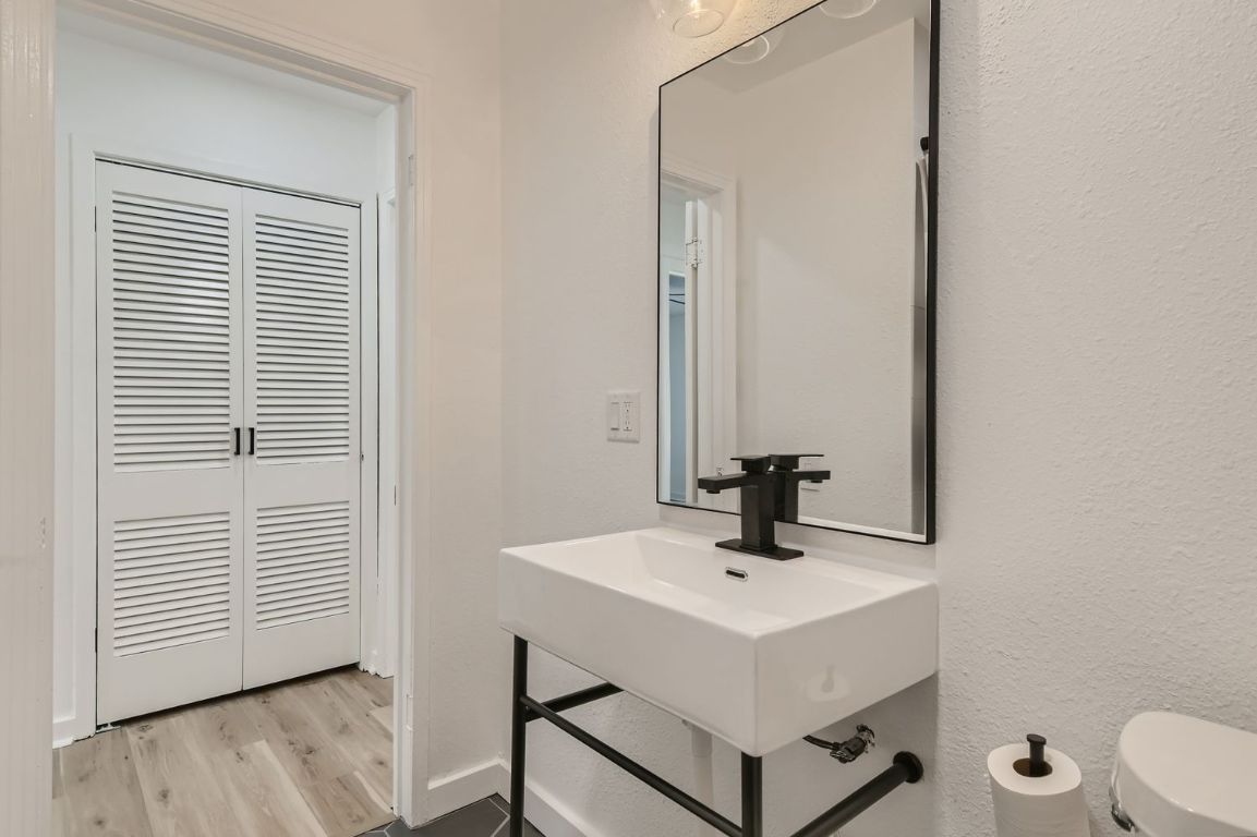 902 Hackberry Street Taylor, TX 76574 - Photo 16 of 29 Half bath with a textured wall, light wood-style flooring, and a closet