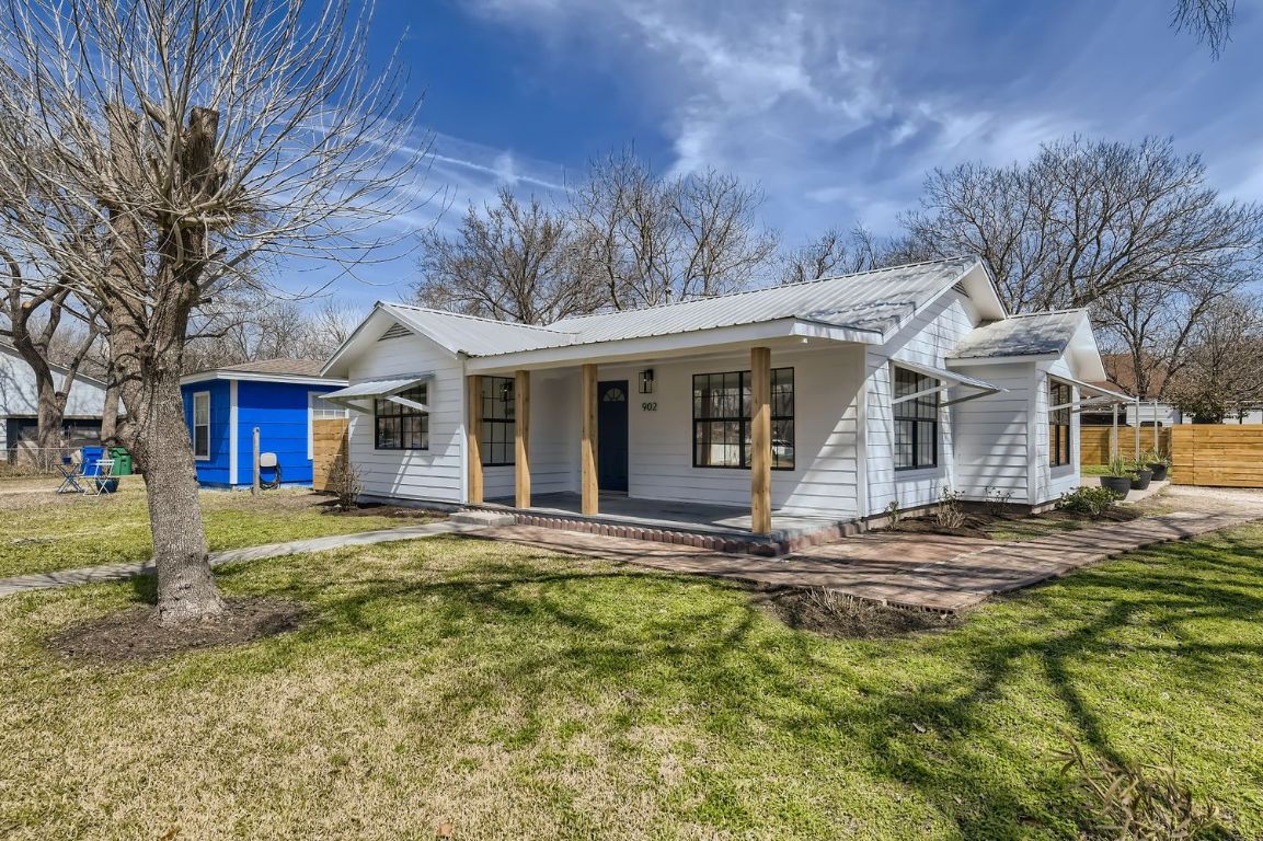 902 Hackberry Street Taylor, TX 76574 - Photo 29 of 29 View of front facade featuring covered porch, a front yard, and a metal roof