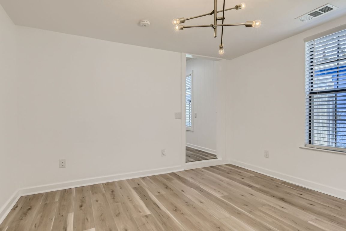 902 Hackberry Street Taylor, TX 76574 - Photo 8 of 29 Spare room with light wood-style floors and a chandelier