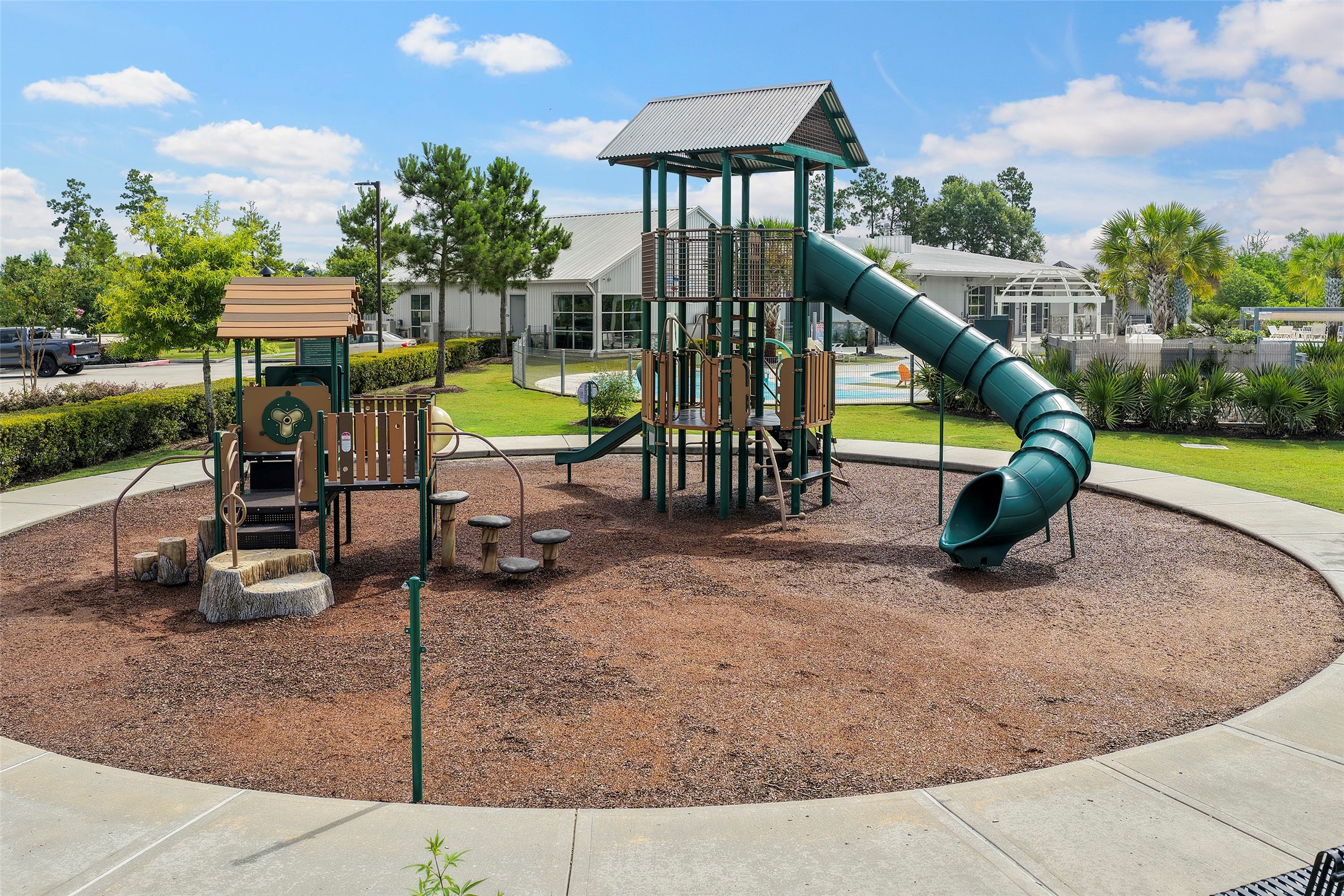 10603 Whitejacket Conroe, TX 77385 - Photo 36 of 42 This photo showcases a community playground with a modern play structure, featuring slides and climbing areas, surrounded by lush greenery and nearby amenities. Perfect for families with children!