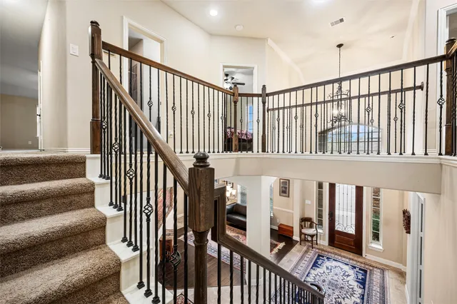 a view of staircase with lots of frames on wall and a window
