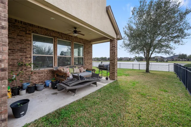 a view of a patio with table and chairs potted plants and a large tree