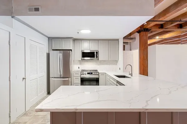 a kitchen with granite countertop a refrigerator and a sink