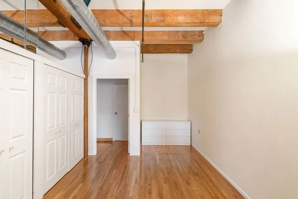 a view of a small space with wooden floor and a gate