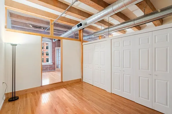 a view of empty room with wooden floor