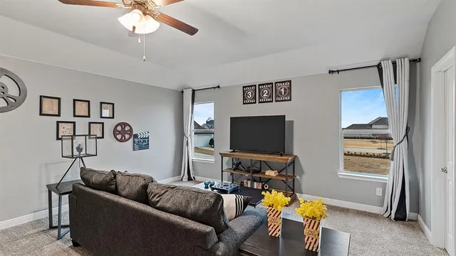 a living room with furniture a ceiling fan and a window