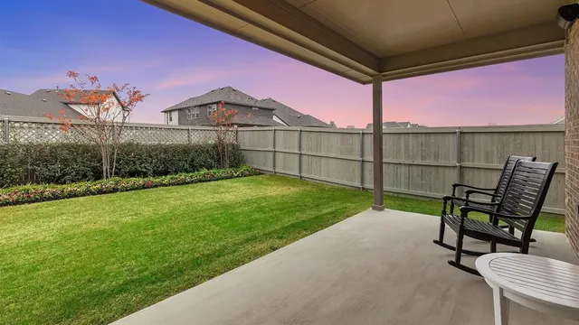 a view of a backyard with sitting area and wooden fence