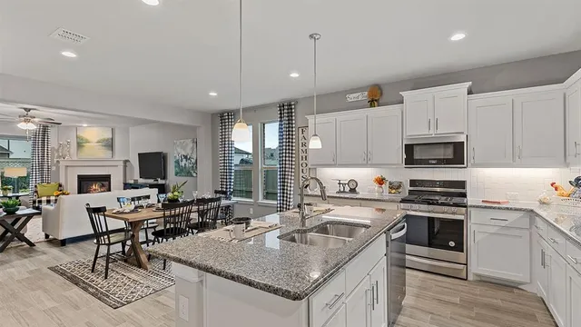 a kitchen with a refrigerator a sink cabinets and wooden floor