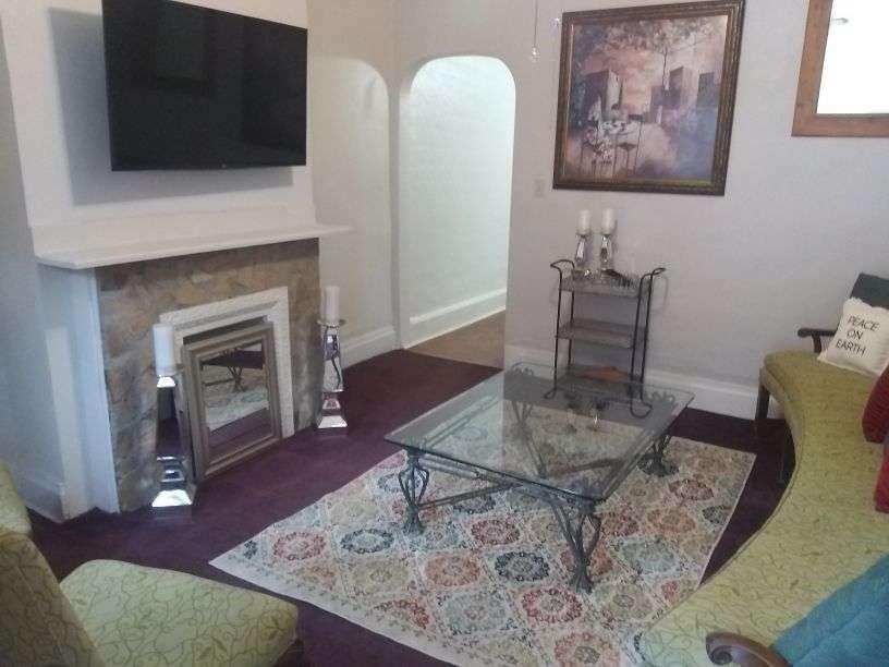 4618 Plummer Street Pittsburgh, PA 15201 - Photo 3 of 8 a living room with furniture a flat screen tv and a fireplace