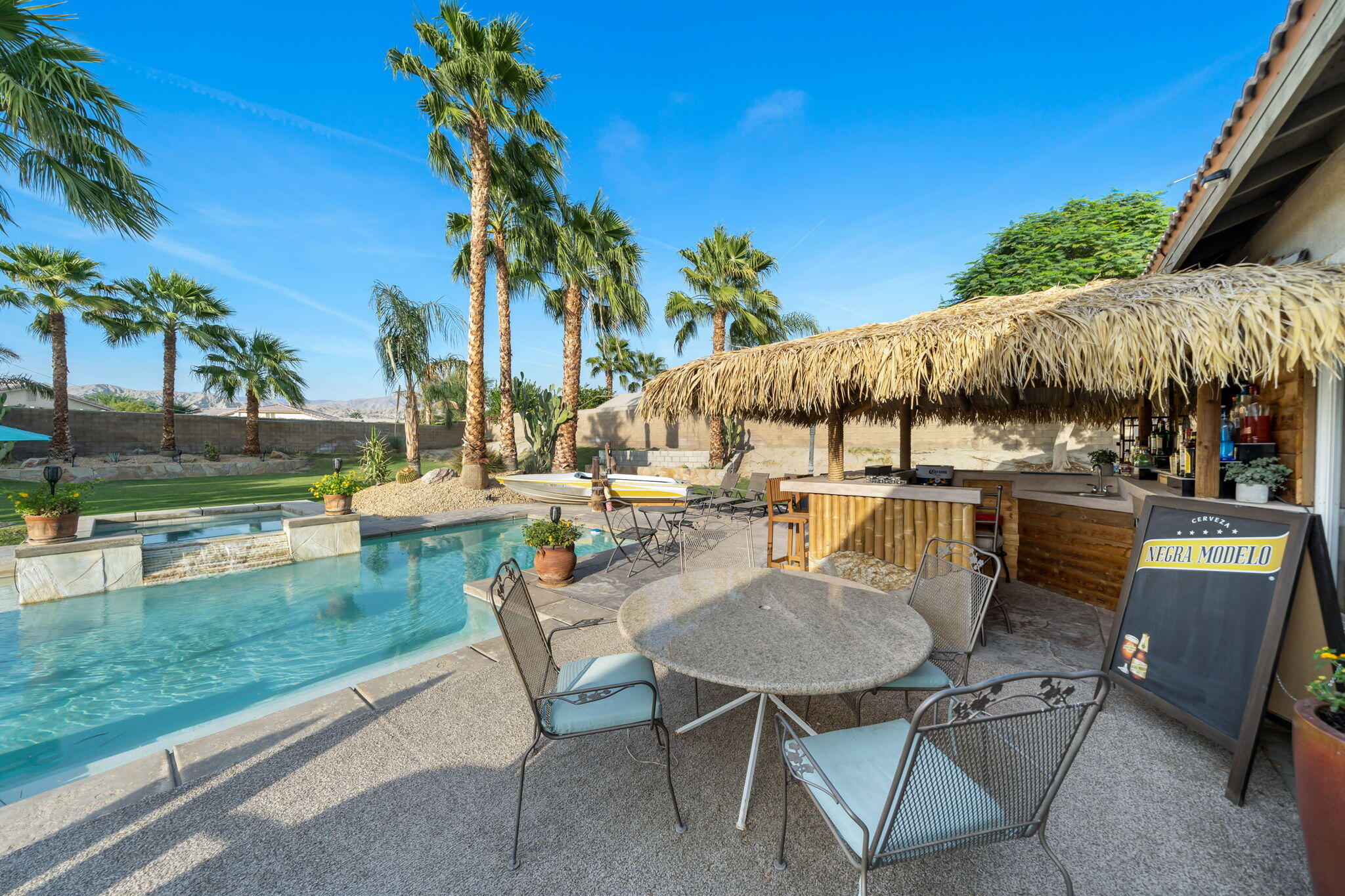 83258 Brighton Crest Drive Indio, CA 92203 - Photo 24 of 69 a view of a patio with table and chairs potted plants and palm tree
