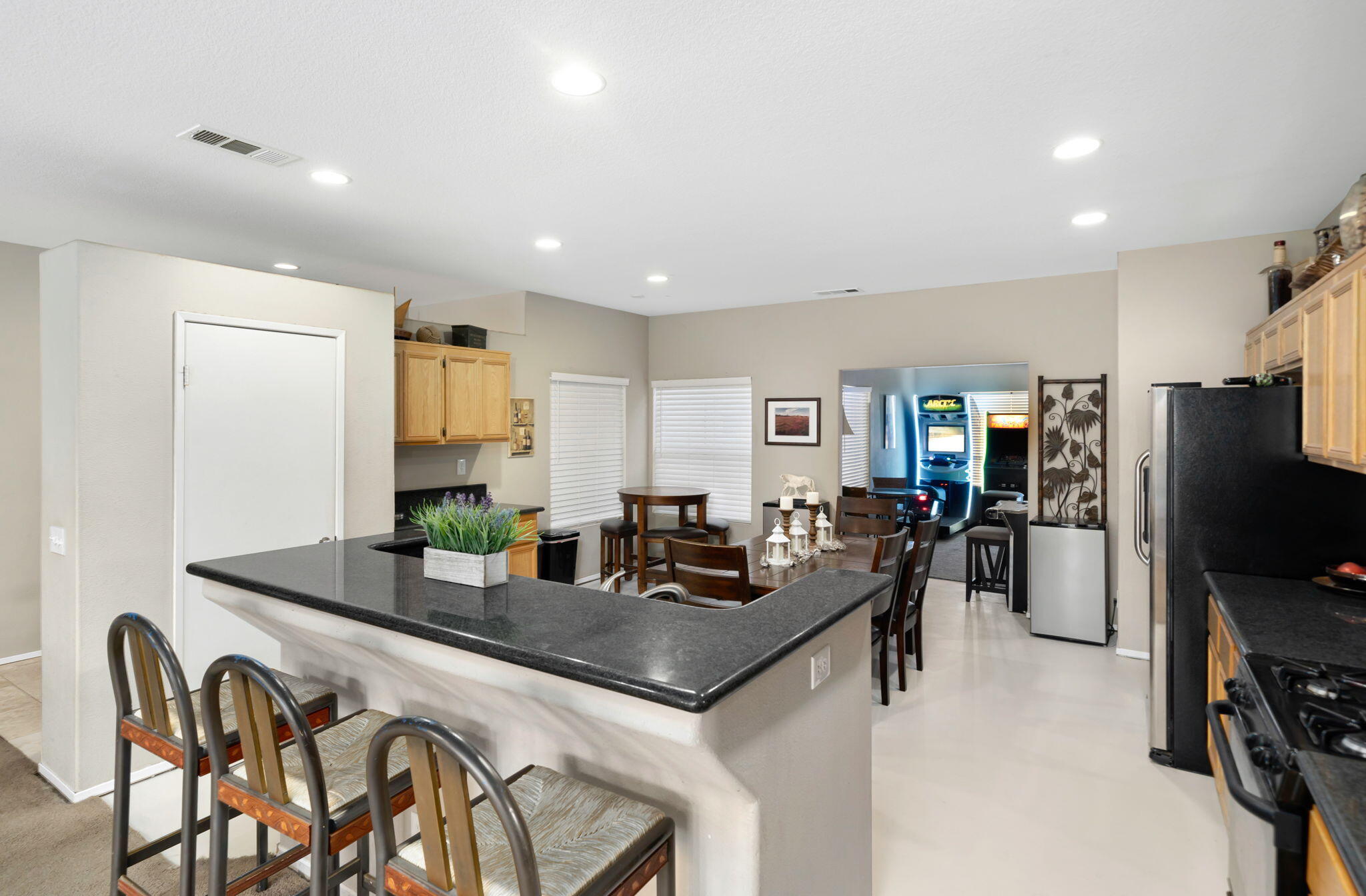 83258 Brighton Crest Drive Indio, CA 92203 - Photo 38 of 69 a kitchen with stainless steel appliances granite countertop a stove a refrigerator a sink a dining table and chairs with wooden floor