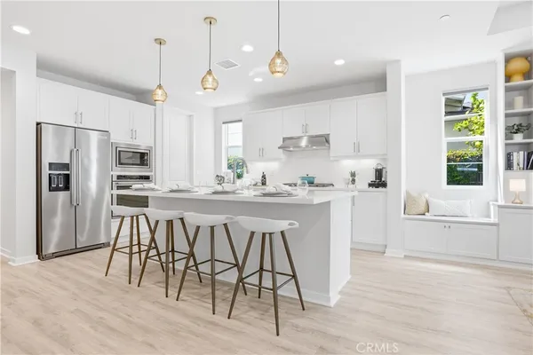 a kitchen with stainless steel appliances kitchen island granite countertop a refrigerator and wooden cabinets