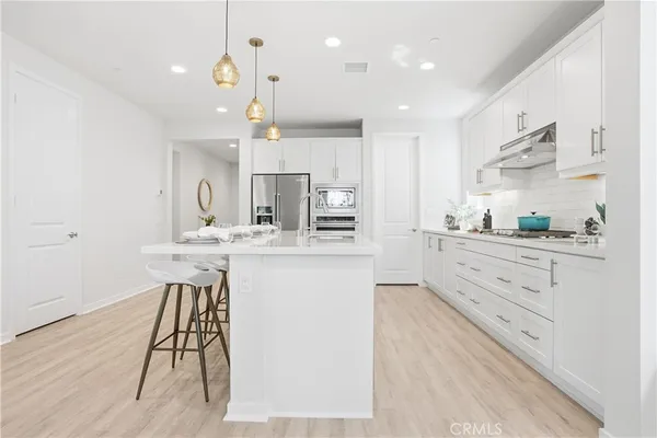 a kitchen with kitchen island a sink stainless steel appliances and cabinets