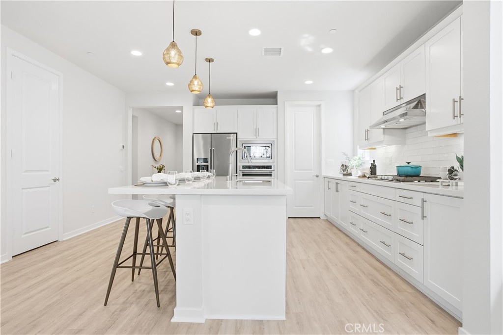 22 Jarano Street Rancho Mission Viejo, CA 92694 - Photo 6 of 75 a kitchen with kitchen island a sink stainless steel appliances and cabinets