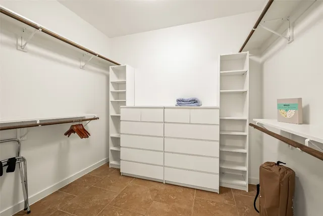 a view of walk in closet with clothes and shoes