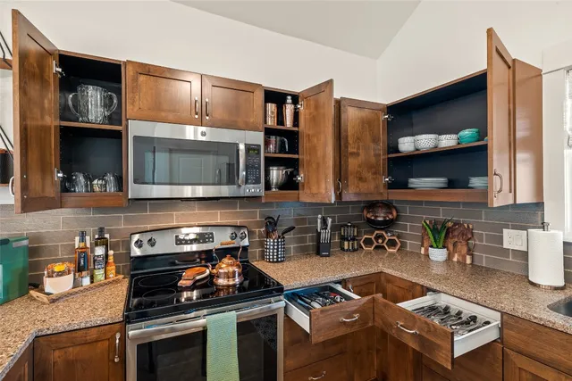 a kitchen with stainless steel appliances granite countertop a stove and a microwave