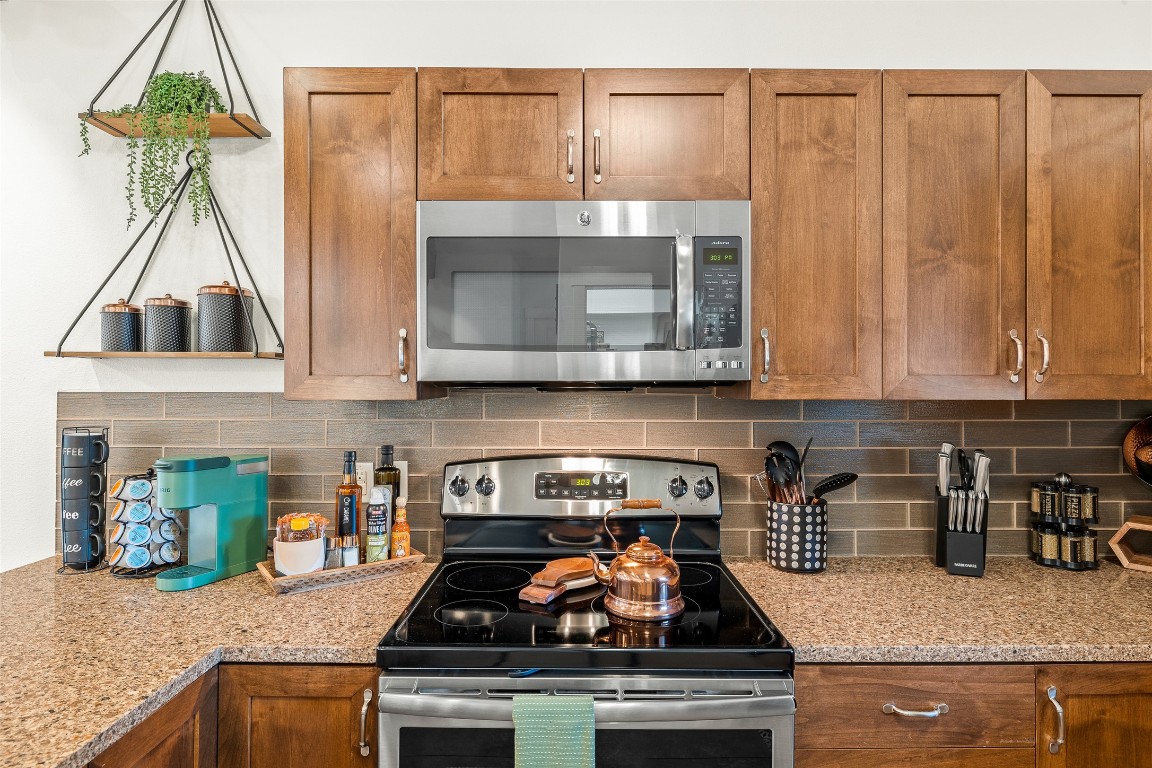 435 Hays Street Dripping Springs, TX 78620 - Photo 30 of 36 a kitchen with stainless steel appliances granite countertop a stove a sink and a microwave