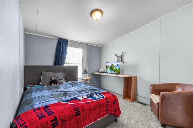 a bedroom with a bed and a lamp on table