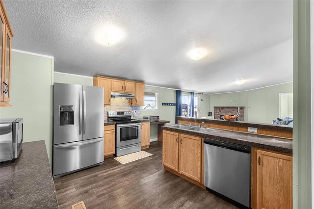 a kitchen with stainless steel appliances granite countertop a refrigerator a stove a sink and a refrigerator