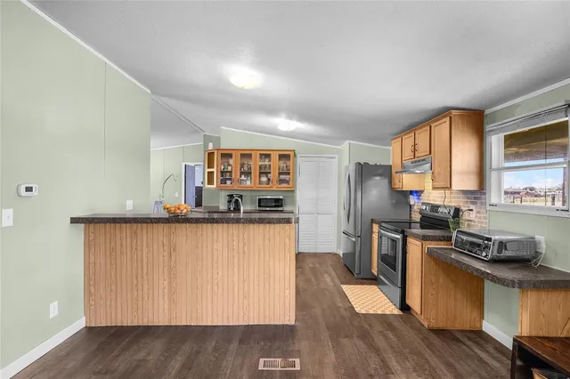 a kitchen with stainless steel appliances granite countertop a stove a sink a refrigerator and a refrigerator