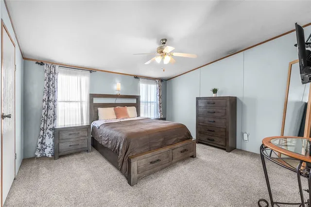 a spacious bedroom with a bed and a chandelier