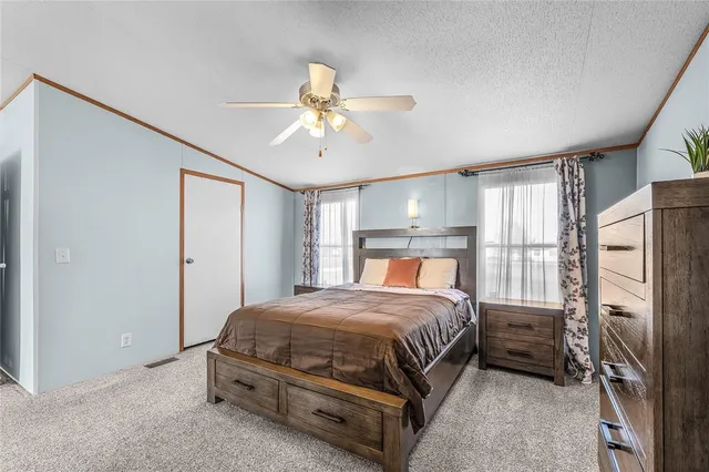 a bedroom with a bed a window and a chandelier