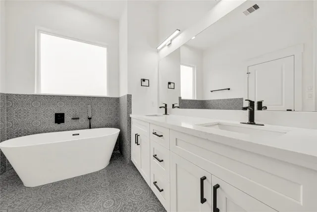 a spacious bathroom with double vanity and a bathtub