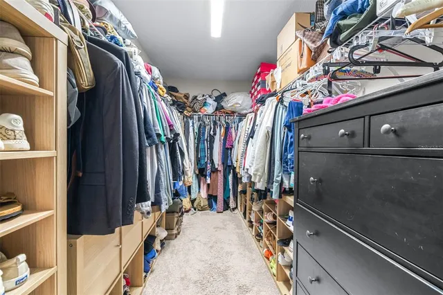 a view of walk in closet with clothes